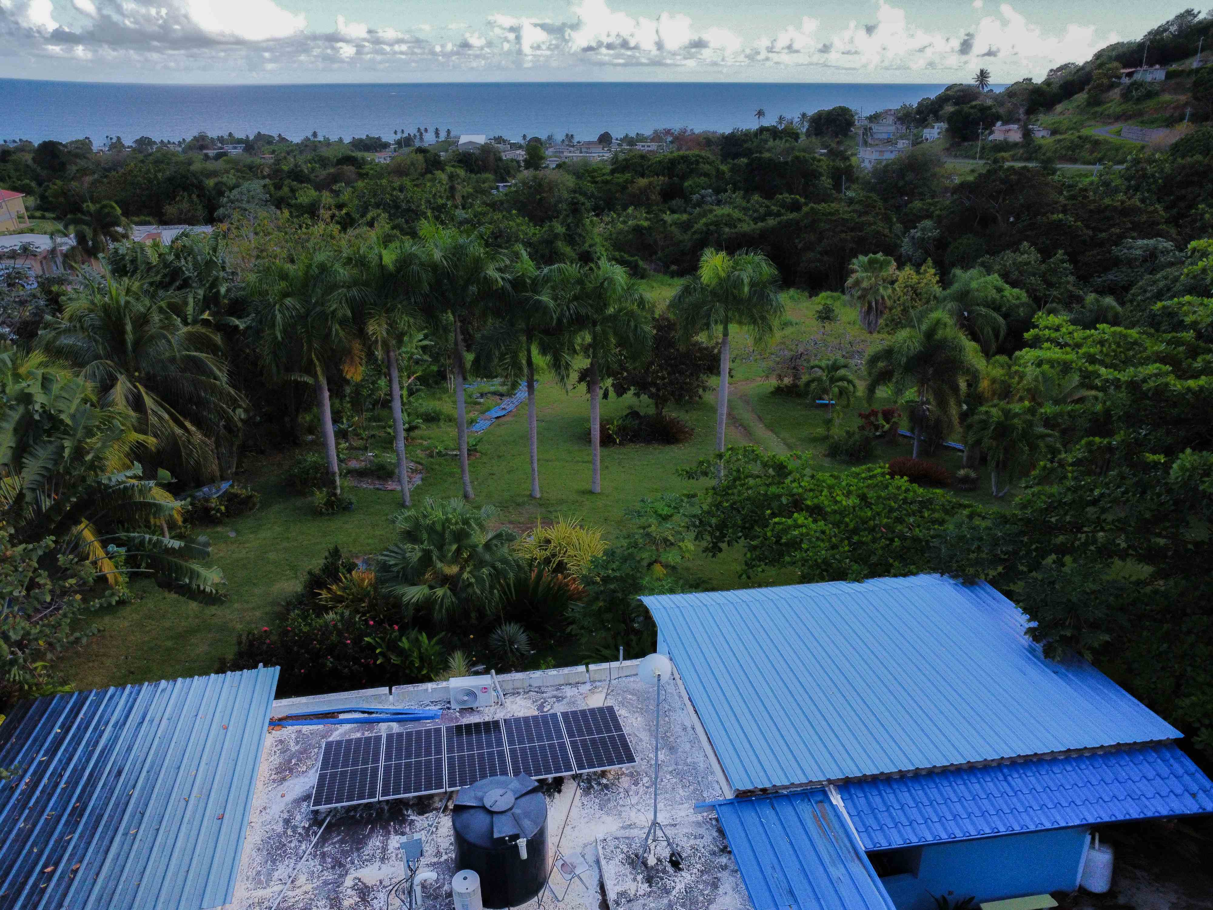 Vista aerea de finca con paneles solares y oceano